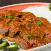 Iskender Plate · Gyro Slices Over Taziki and Hot Sauce Pita Bread Topped With Iskender Tomato Sauce and Serve...