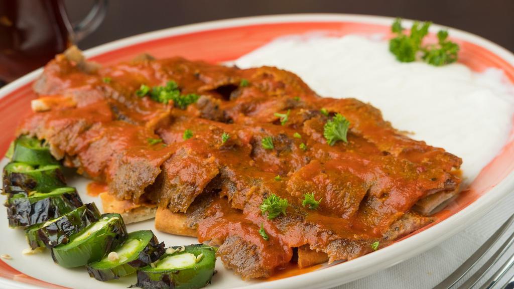Iskender Plate · Gyro Slices Over Taziki and Hot Sauce Pita Bread Topped With Iskender Tomato Sauce and Served With Grill Pepper