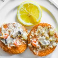 Louisiana Crabcakes · Two crab cakes topped with crawfish cream sauce.