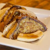 Jamaican French Toast · Thick slices of our cinnamon bread topped with flambéed bananas in spiced rum, brown sugar a...