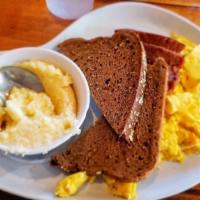 Café Breakfast · Two eggs, with a choice of meat, choice of roasted potatoes or fruit or creamy grits, and to...
