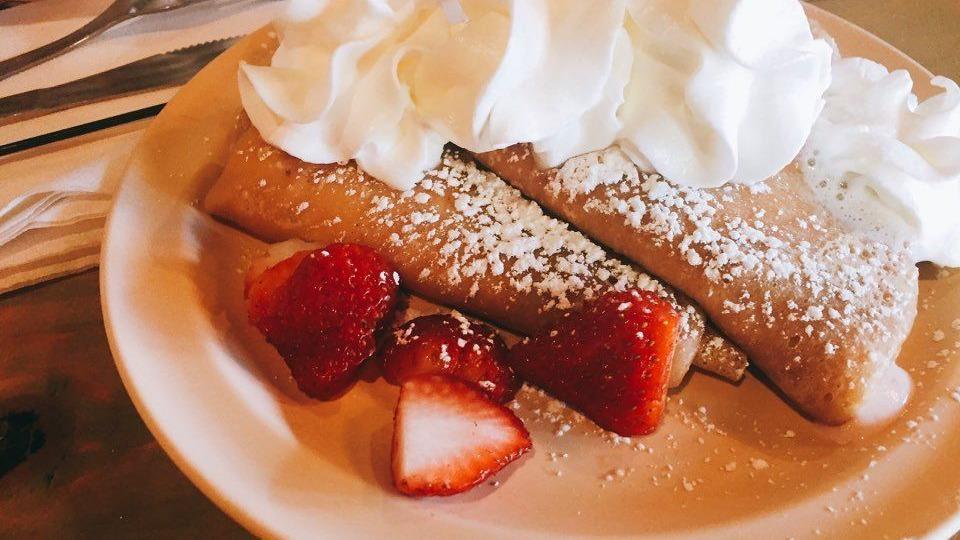 Buttermilk Pancakes · Homemade pancakes topped with fresh fruit and powdered sugar.