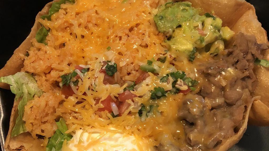 Ground Beef Ensalada Supreme · Fried tortilla shell filled with romaine lettuce, rice, beans, topped with cheddar cheese, guacamole, pico de gallo, sour cream