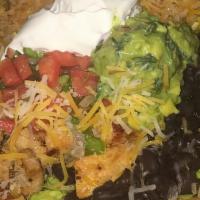 Shredded Chicken Ensalada Supreme · Fried tortilla shell filled with romaine lettuce, rice, beans, topped with cheddar cheese, g...