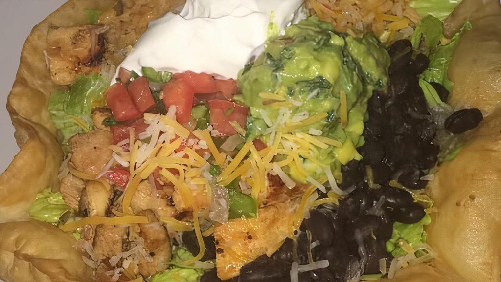 Shredded Chicken Ensalada Supreme · Fried tortilla shell filled with romaine lettuce, rice, beans, topped with cheddar cheese, guacamole, pico de gallo, sour cream