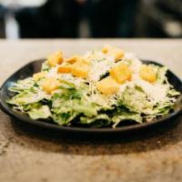 Caesar Salad · Romaine lettuce tossed in caesar dressing topped with parmesan and croutons.