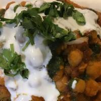 Samosa Chaat · Crumbled samosa topped with chickpeas, yogurt, onions, cilantro, fresh ground spices, mint a...