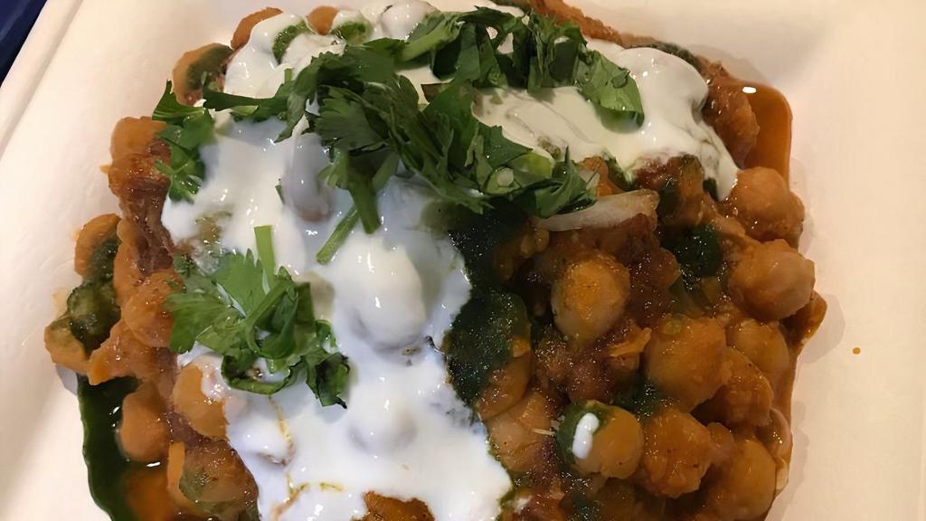 Samosa Chaat · Crumbled samosa topped with chickpeas, yogurt, onions, cilantro, fresh ground spices, mint and tamarind chutney.