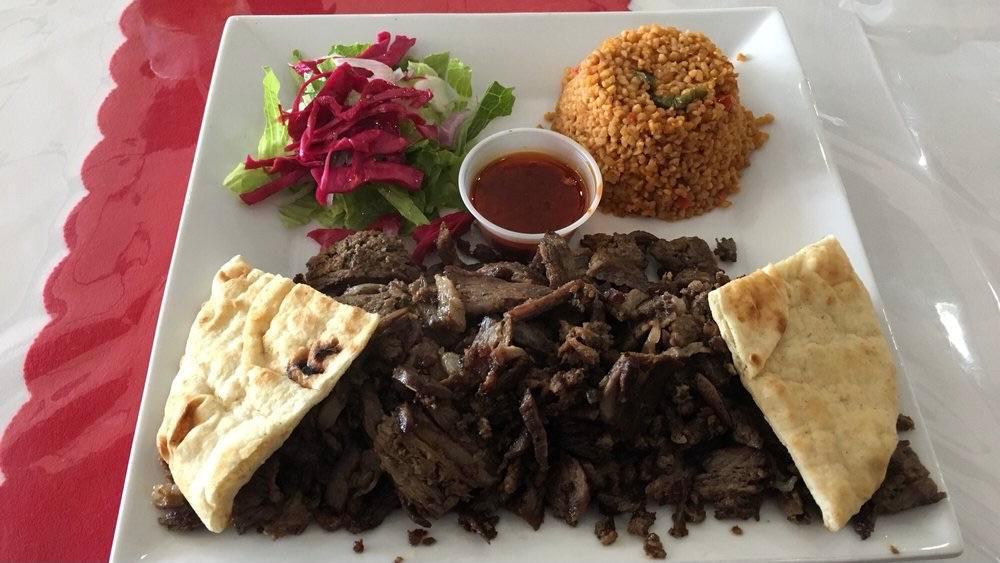 Doner Kebab · Shaved lamb marinated with fresh onions olive oil black pepper and oregano all slow cooked on a skew. served with rice or bulgur salad pita bread and tzatziki sauce.