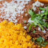 Birria De Res · shredded beef seasoned with dry chiles, served with rice, beans and homemade tortillas