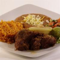 Carnitas Dinner · Chunks of pork served with rice, beans, guacamole, salad, and tortillas.