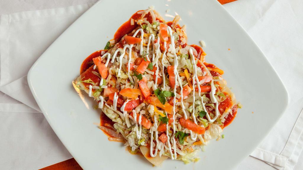 Enchiladas Deluxe · One beef, one chicken, one cheese and one bean enchiladas topped with ranchera sauce, lettuce, tomato, and sour cream.