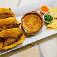 Toro Al Carbon · Three steak tacos, charro beans, one sincronizada and pico de gallo.