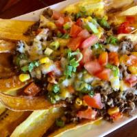 Platanitos “La Gloria” · Crispy plantain nachos topped with ground beef, onions, bell peppers, tomatoes, corn, aguaca...
