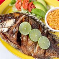 Mojarra Frita · Deep-fried tilapia (whole fish) served with Mexican rice, lettuce, onions, and avocado.