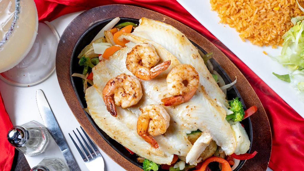 Fajitas Del Mar · Shrimp and grouper fillet, served steaming hot on a bed of zucchini, broccoli, cauliflower, onions, bell peppers, and carrots. Served with Mexican rice, pico de gallo, lettuce, sour cream, guacamole, and warm flour tortillas.