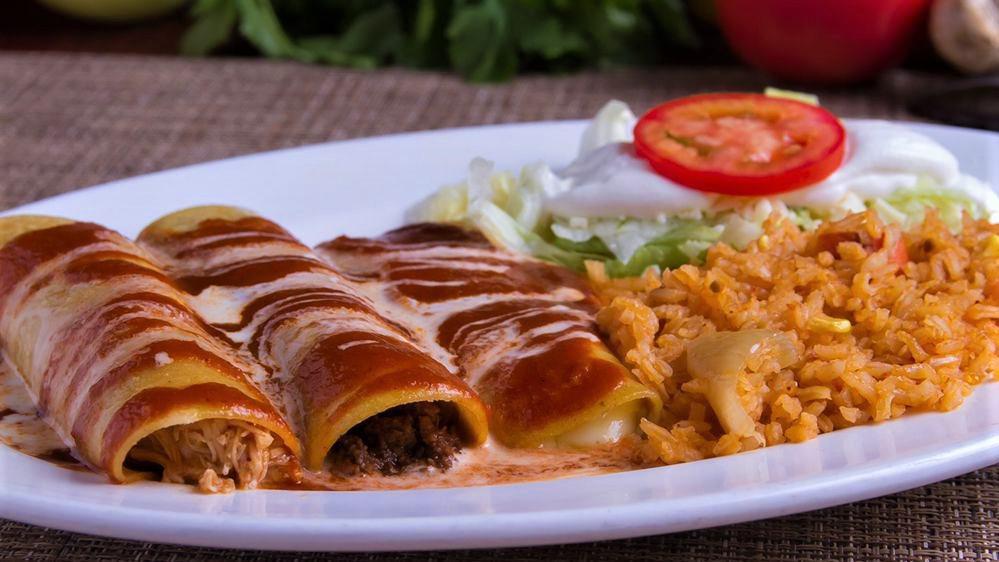 Enchiladas Supremas · One chicken enchilada, one beef enchilada, and one cheese enchilada, all smothered with a freshly made sauce, melted cheese, lettuce, sour cream, and tomatoes. Served with a side of Mexican rice.