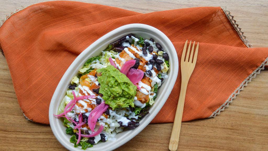 Bajo Bowl · Superfood lettuce blend tossed in olive oil, lime juice dressing, cilantro rice, black beans, sweet corn, guacamole, pickled red onion, salsa, and crema.