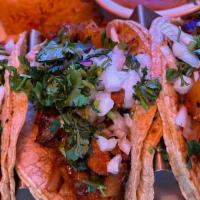 Tacos Al Pastor · Three tortillas filled with marinated pork, grilled onion and pineapple. Served with rice, b...