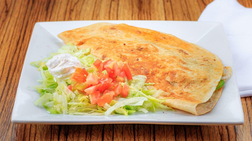 Quesadilla Fajita Grande · Large flour tortilla stuffed with cheese and your choice of chicken or steak. Cooked with onions, bell peppers and tomatoes. Served with lettuce, sour cream, guacamole and pico de gallo, rice and beans on the side.