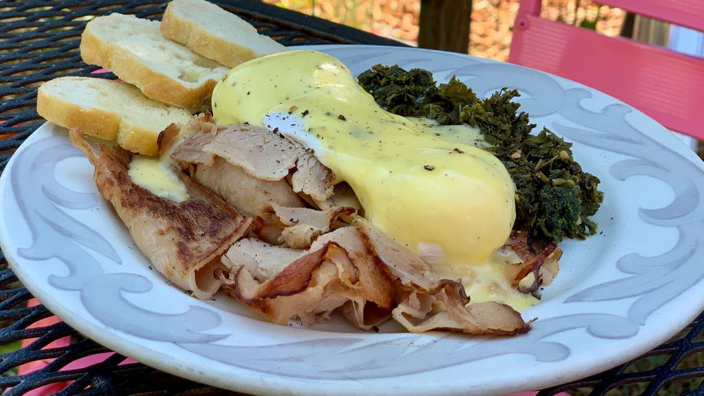 Root Benny · Two farm-fresh poached eggs, local seasonal greens, local ham from Rabbit Ridge, topped with homemade hollandaise and served with toasted baguette slices