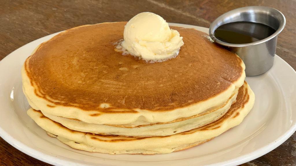 Buttermilk Pancakes · Vegetarian. Stack of three fluffy buttermilk pancakes served with whipped butter and real maple syrup.