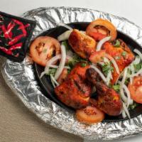 Tandoori Chicken Leg · Whole chicken leg and thigh, spicy marinated and broiled in clay oven.