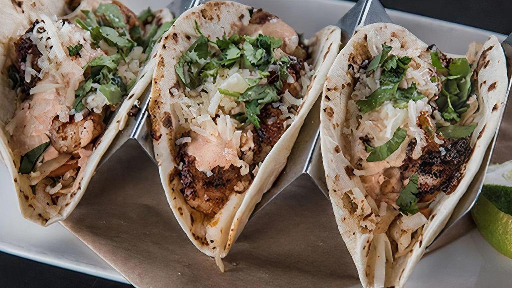 Street Tacos · 3 flour tortillas filled with choice of blackened shrimp or redfish, chipotle slaw, Cotija, and cilantro and tomatillo sauce.