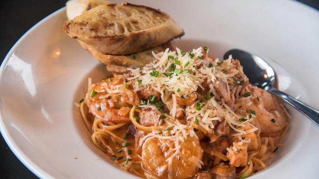Jambalaya Pasta · Chicken, andouille, and shrimp tossed in Cajun spices with linguine, grilled baguette