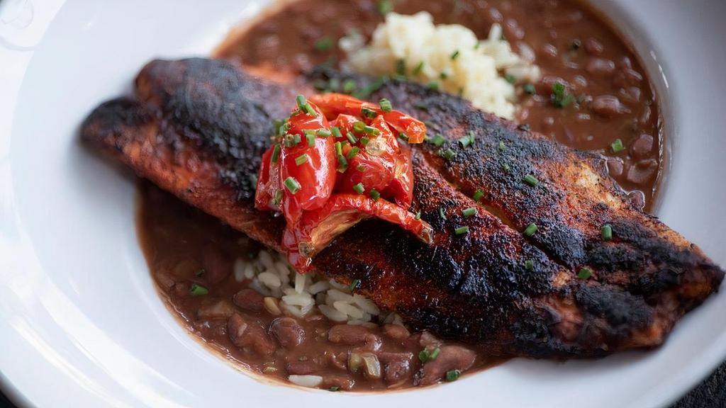 Blackened Redfish · Served over slow cooked N'awlins style red beans and rice with roasted tomatoes *Gluten Free