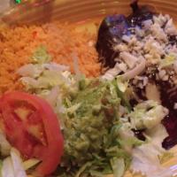 Enchiladas Poblanas · Two chicken enchiladas with rich poblano sauce (made with spices and chocolate). Served with...