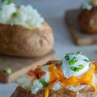 Loaded Baked Potato · Baked potato loaded with butter, sour cream, chopped bacon, and cheddar cheese, then garnish...