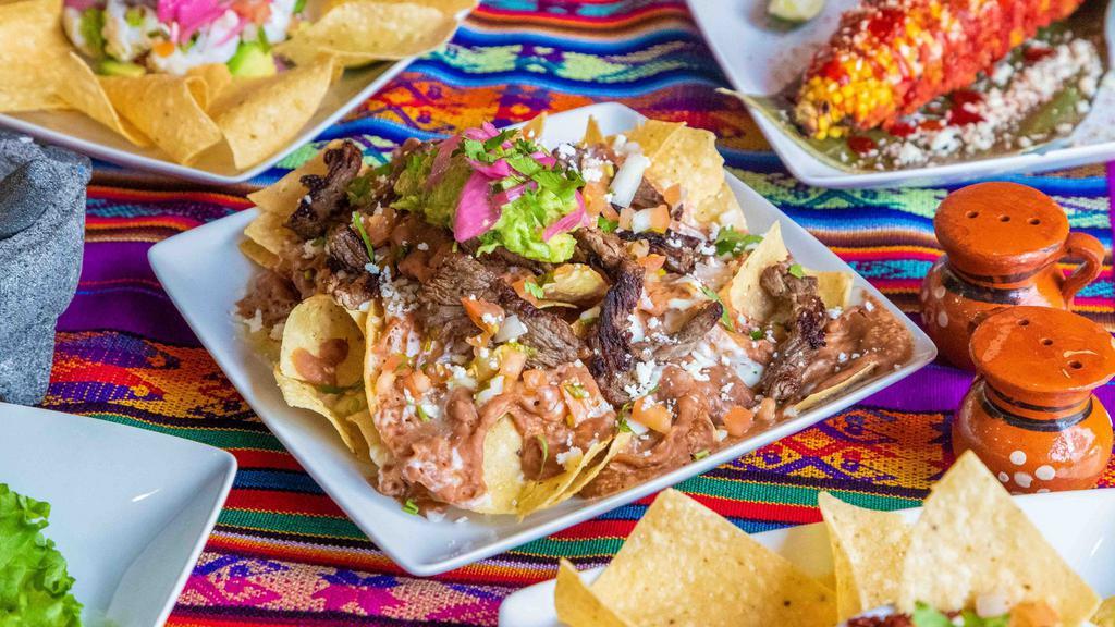 Nachos · Chips with: beans, pico de gallo, guacamole, cheese, and sauce. Served with your choice of meat: Chicken, Ground Beef, Steak, Sautéed Vegetables.