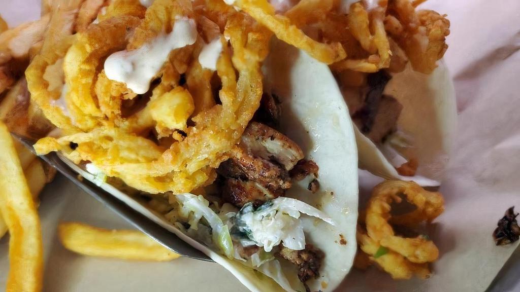 Jerk Tacos · Jerk chicken on a bed of cabbage slaw, topped with crispy onion strings & chipotle ranch.