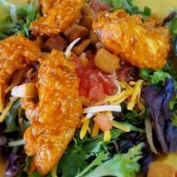 Buffalo Chicken Salad · Our hand breaded tenders tossed in your choice of sauce over mixed greens with cheddar jack ...