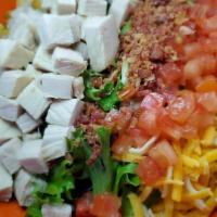 Turkey Chef Salad · Smoked shaved turkey on a bed of mixed greens, layered with diced tomatoes, cheddar jack che...