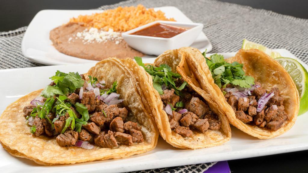 Tacos · Three tacos served taco truck-style. Soft corn tortillas loaded with your choice of meat, diced onion and cilantro. Served with tomatillo salsa, rice, choice of refried or black beans.
