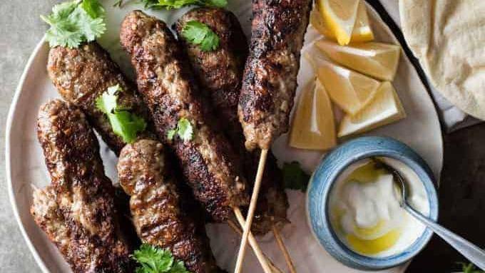Beef Kofta · two skewer of Charbroiled ground beef sirloin seasoned with fresh onions with special spices. Served with two sides of your choice of hummus+pita bread or salad or rice