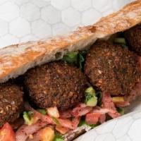 Falafel Baguette · Tzatziki, romaine, cucumber tomato salad and sumac onions.  Finished with fresh falafel and ...