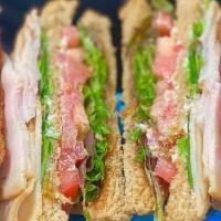 Turkey Club · Sliced turkey, bacon, provolone cheese, spring mix and our house made onion jam on sliced br...