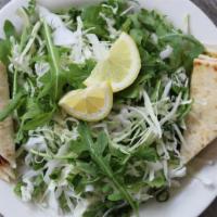 Lahano Salata · Thinly sliced cabbage with arugula, green onions and dill tossed in a lemon juice and olive ...