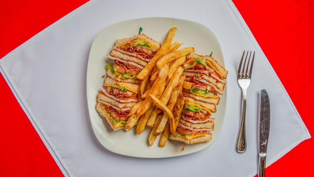 Triple Decker Club · Smoked turkey breast, bacon, tomato, lettuce, and mayo on wheat toast. Served with fries.