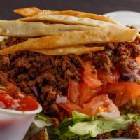 Taco Salad · Fresh iceberg lettuce topped with seasoned ground beef, tomatoes, onions, shredded cheese, d...
