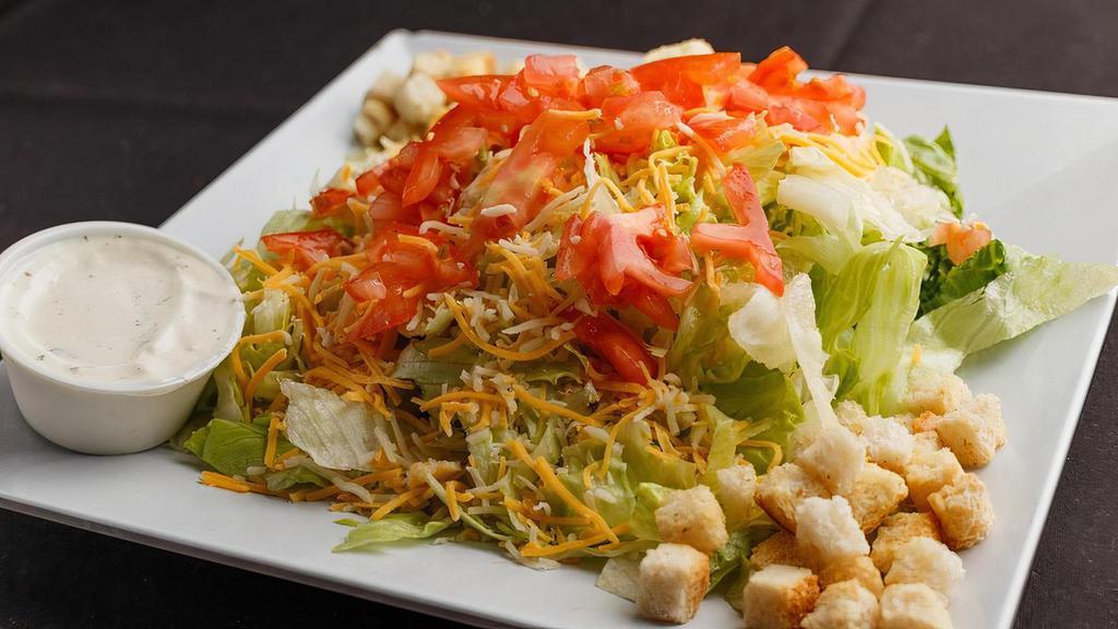 Garden Salad · Fresh iceberg lettuce, tomatoes, onions, and shredded cheese. Topped with croutons and your choice of dressing.