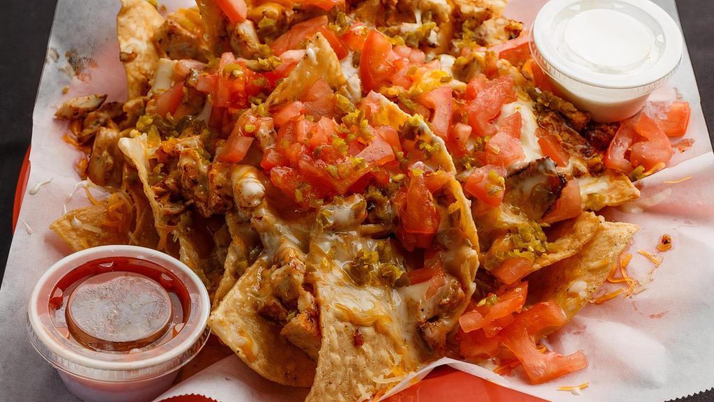 The Classic Nachos · Freshly fried corn tortilla chips with your choice of meat piled high with toppings. Topped with diced tomatoes, jalapenos, queso cheese, and shredded Cheddar and Jack cheese blend.