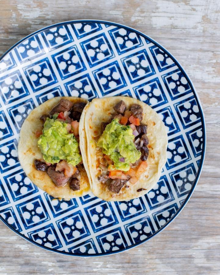 Tacos Carne Asada (2) · steak (cooked to order) / cheese / guacamole / pico de gallo. Two soft flour tortilla tacos served with rice and beans