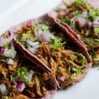 Tacos Carnitas (3) · Slow roasted pork with morita salsa / cilantro / onions. Three blue corn tortilla tacos serv...