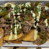 Carnitas Nachos · Pork carnitas, melted cheese, black beans, chipotle honey, pickled red onions, jalapeños, an...