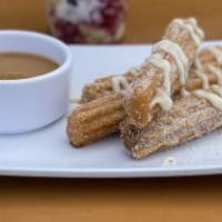 Cinnamon Roll Churros · Topped with vanilla icing and served with Mexican salted caramel.