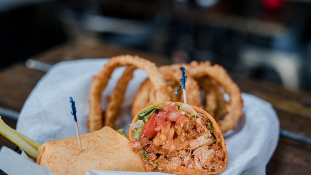 Spicy Buffalo Chicken Wrap · fried chicken strips tossed in buffalo sauce, bleu cheese crumbles, banana peppers, greens, tomatoes, & red onion